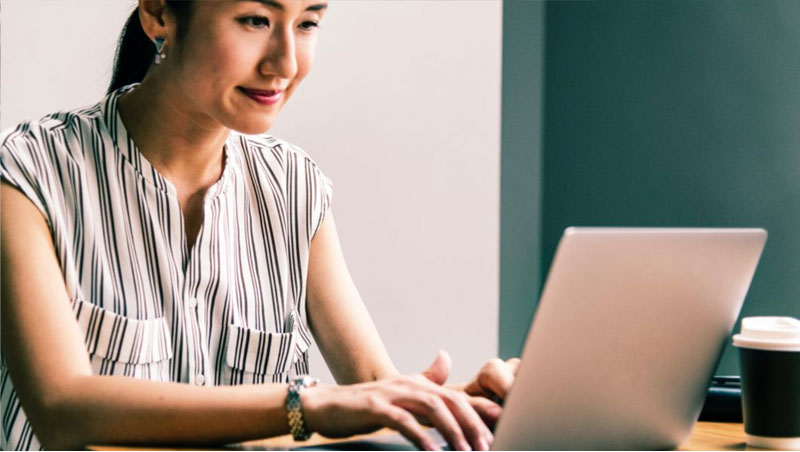 Photo: Asian female typing on laptop