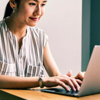 Photo: Asian female typing on laptop